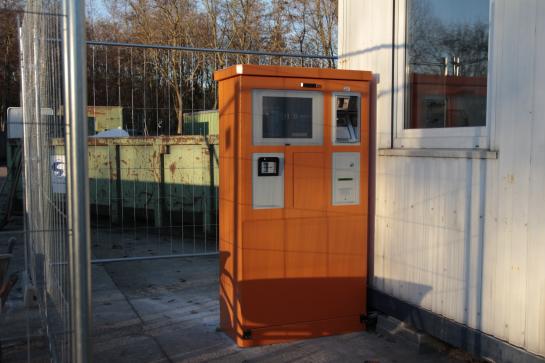 Je vindt de betaalautomaat naast de bureaucontainer van de parkwachter.
